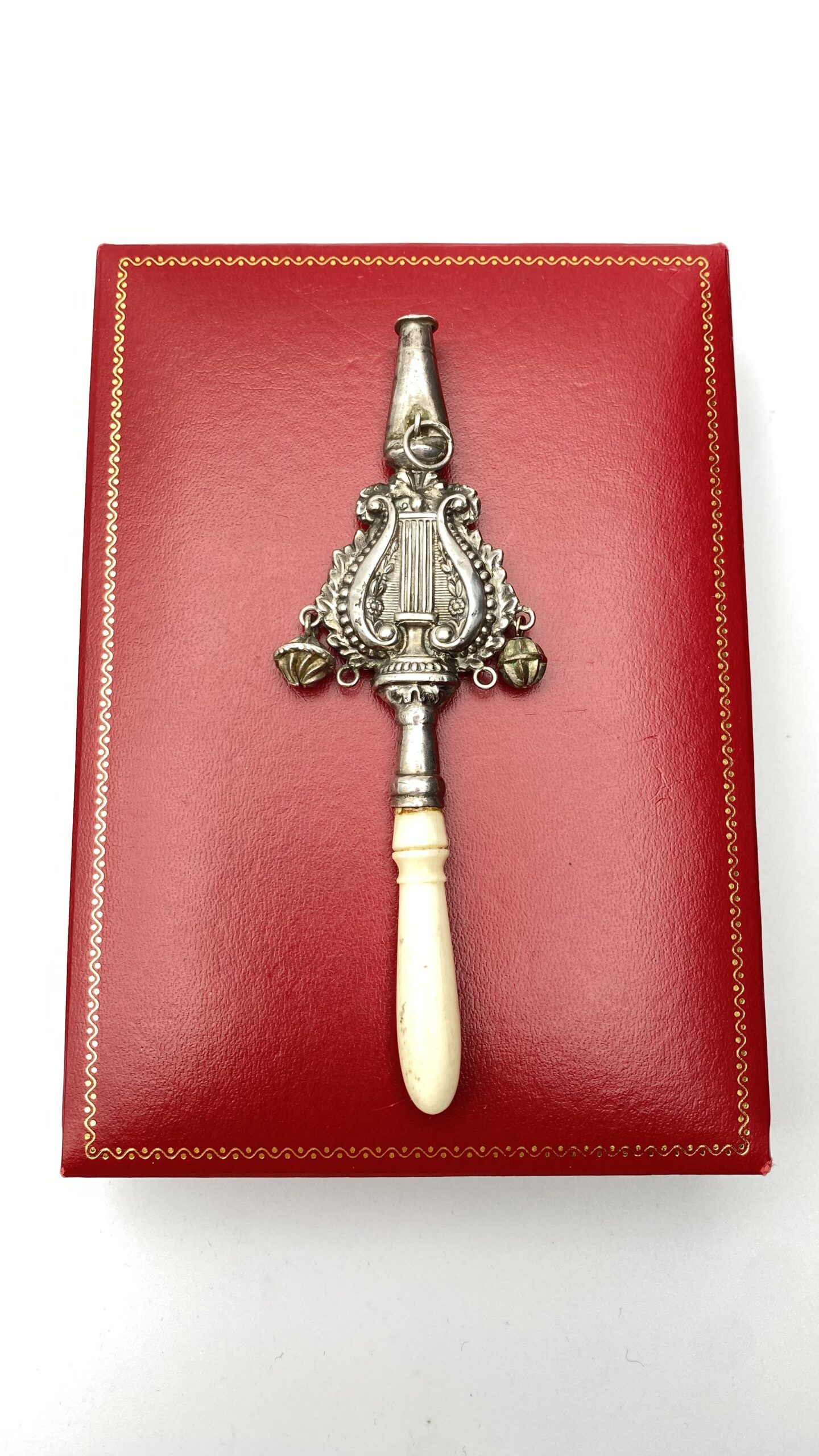 RARO BABY RATTLE IN ARGENTO FINEMENTE SAGOMATO A FORMA DI CETRA, CON FISCHIETTO E PICCOLI CAMPANELLI. PROVENIENZA FRANCESE, 1700.