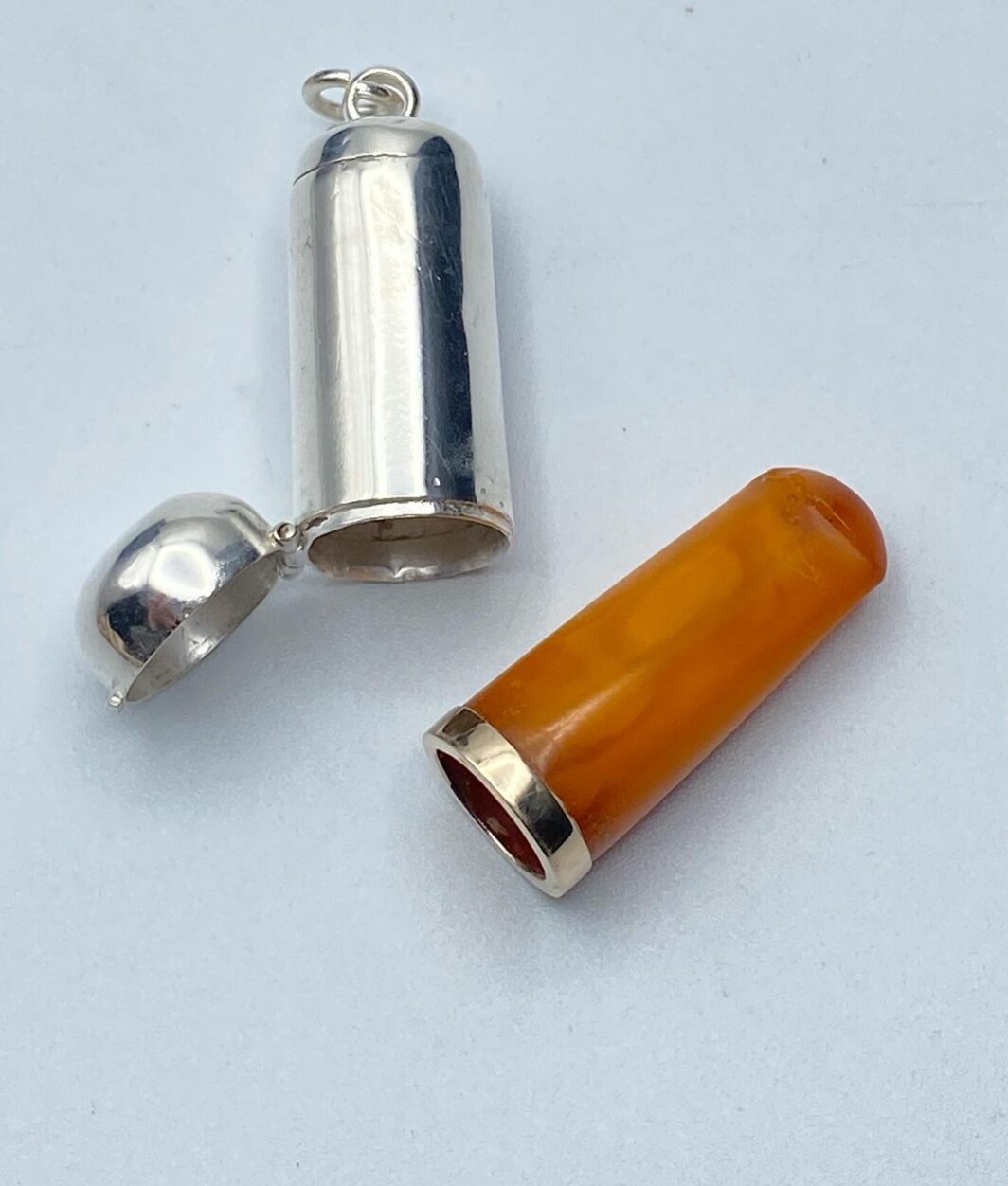 CANNELLO IN AMBRA E ORO BASSO CON CUSTODIA ORIGINALE IN ARGENTO. INGHILTERRA, EPOCA GIORGIO V, 1920ca.