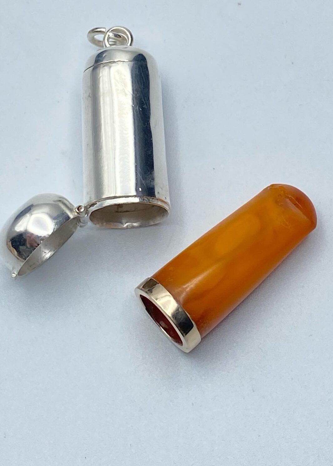 CANNELLO IN AMBRA E ORO BASSO CON CUSTODIA ORIGINALE IN ARGENTO. INGHILTERRA, EPOCA GIORGIO V, 1920ca.