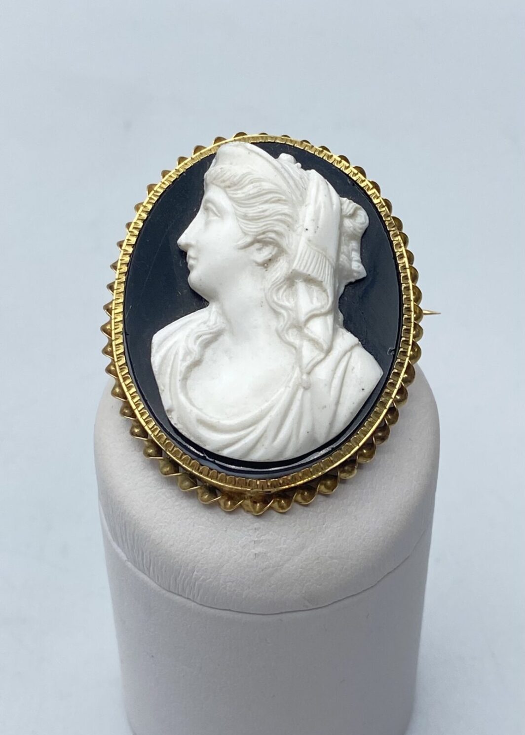 ANTICO CAMEO IN ONICE NERA E BIANCA CON FIGURA DI MATRONA ROMANA E CORNICE IN ORO 18KT. FRANCIA, PRIMA METÀ XIX sec.