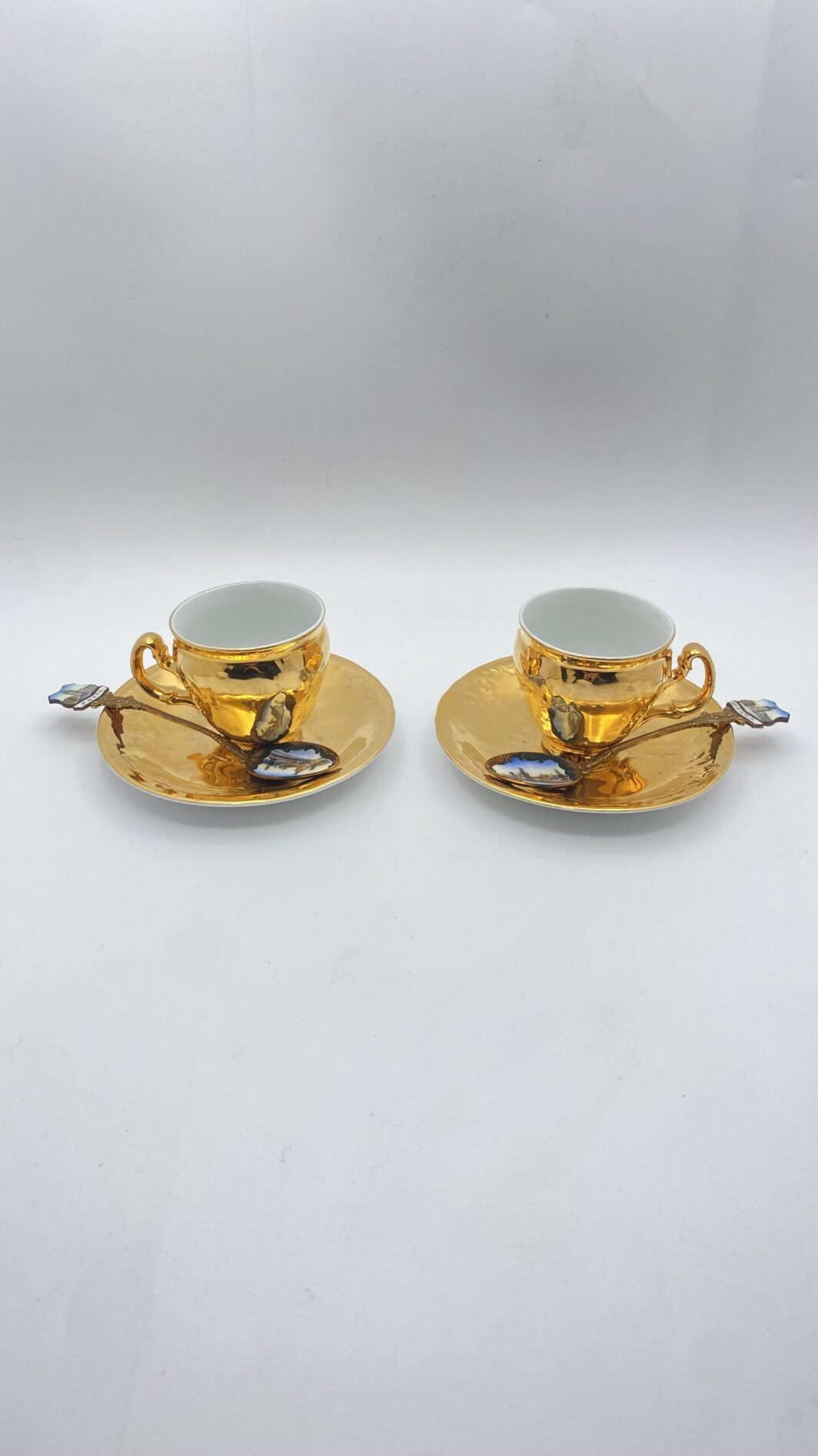 TÊTE-À-TÊTES DI TAZZINE IN PORCELLANA DORATA, CON CUCCHIAINI SMALTATI ORIGINALI. SOUVENIR VINTAGE ANNI ‘50 ca. PRAGA