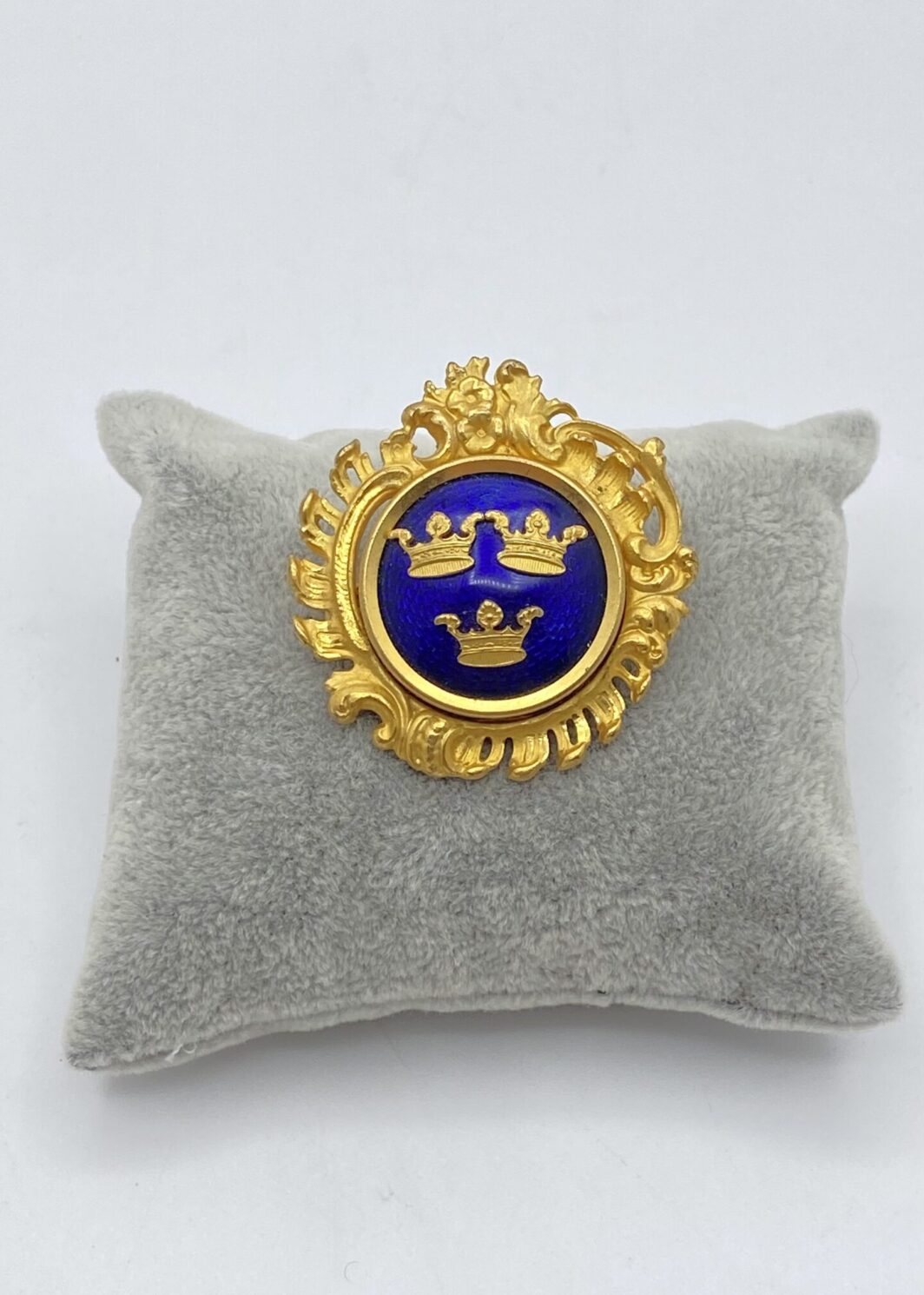 SPORRONG & CO. SPILLA CON STEMMA SVEDESE IN METALLO GOLDTONE E SMALTI.