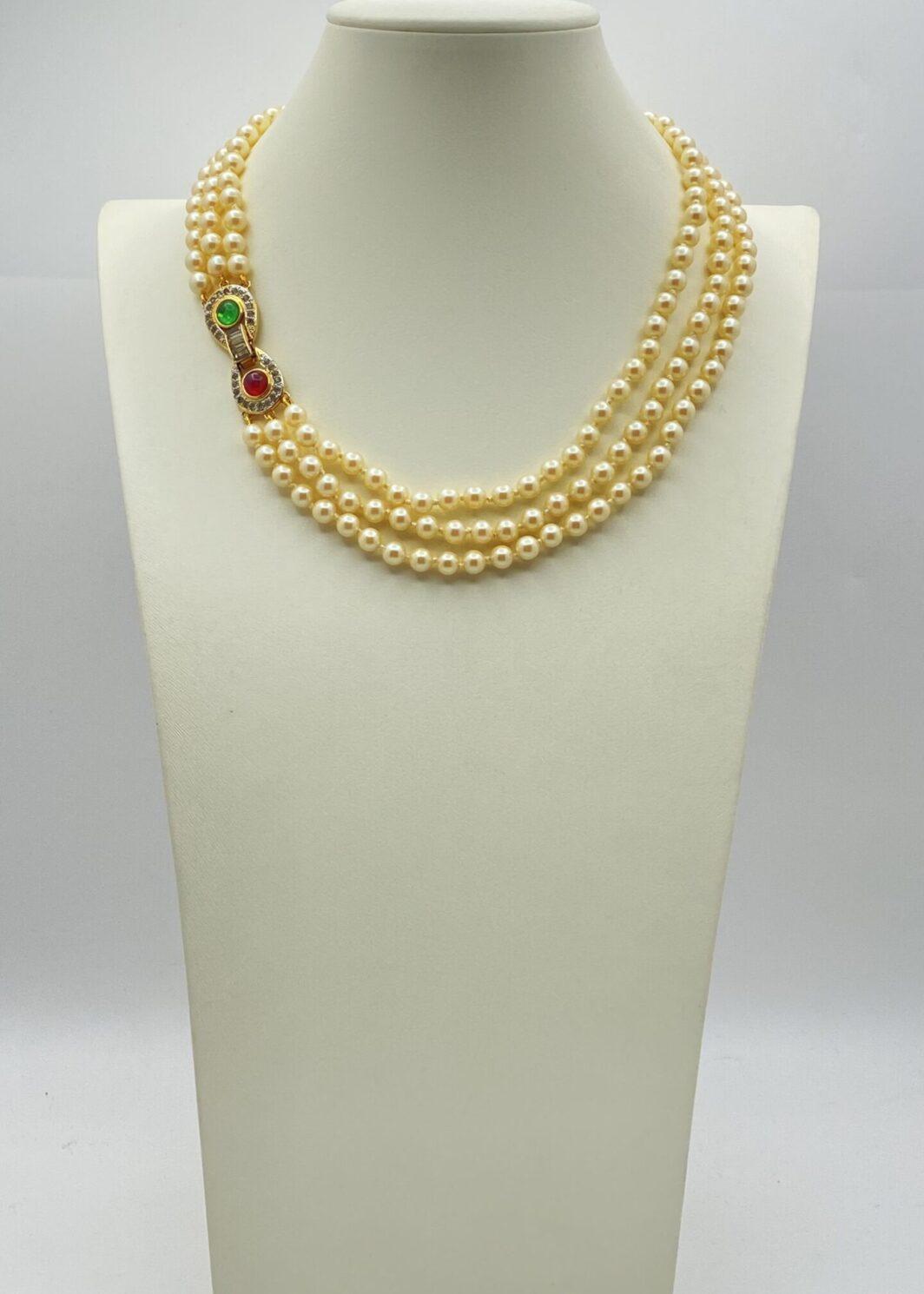 “VOGUE BIJOUX”. COLLANA A TRE FILI DI PERLE CON CHIUSURA IN METALLO GOLDTONE, PASTE DI VETRO COLORATE E CRISTALLI DIAMOND LIKE. BIGIOTTERIA AMERICANA ANNI ‘70