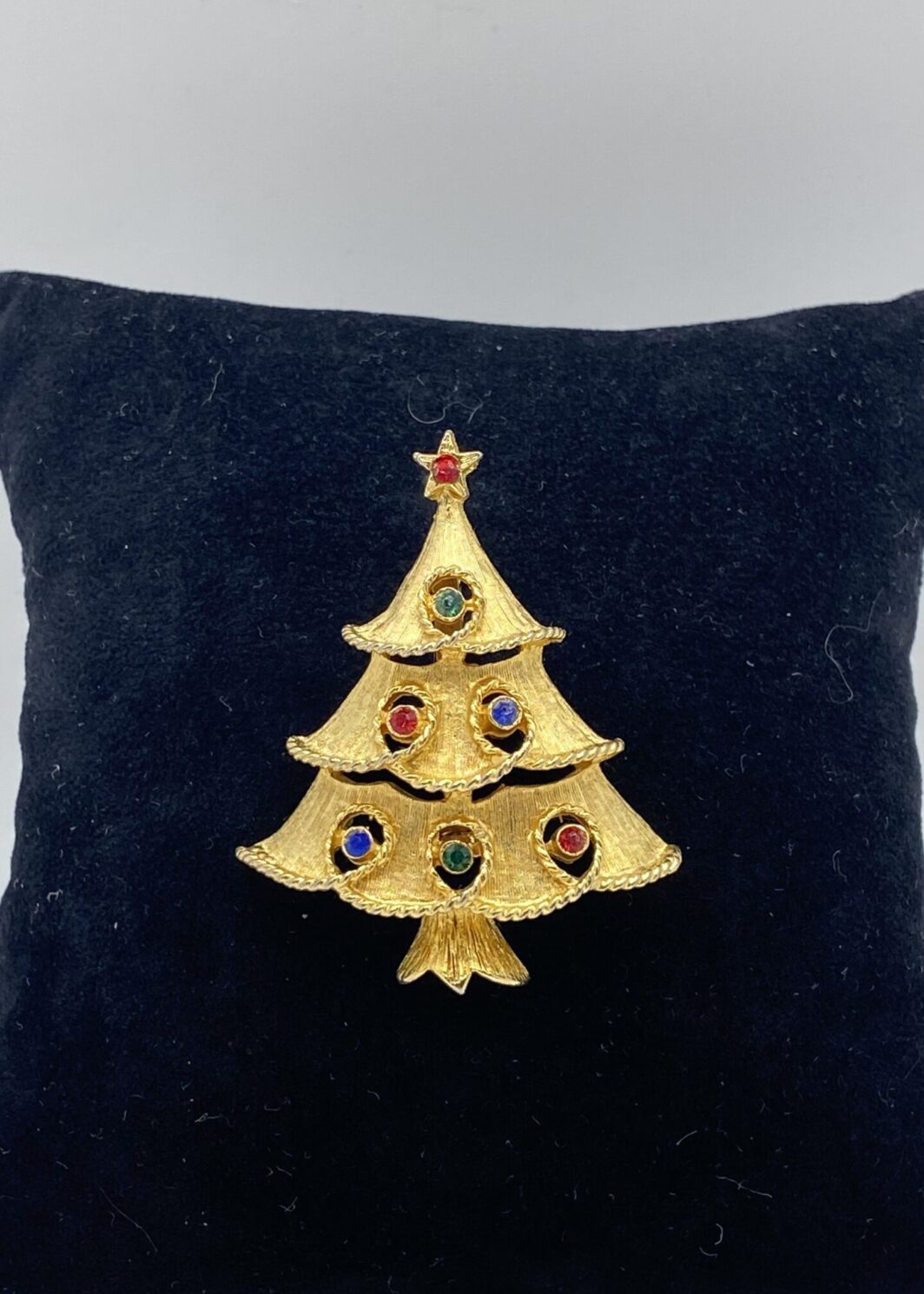 “J.J.” SPILLA VINAGE ANNI ‘50 A FORMA DI ALBERO DI NATALE, IN METALLO GOLDTONE E CRISTALLI POLICROMI. U.S.A.