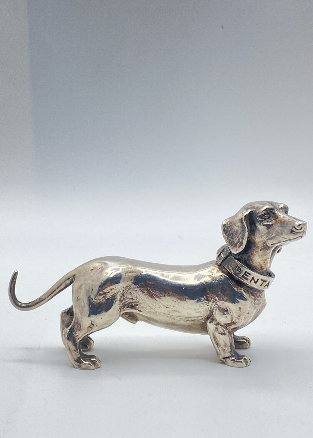 PREGIATA SCULTURA DI CANE BASSOTTO TEDESCO, IN ARGENTO, REALIZZATA CON TECNICA DELLA FUSIONE A CERA PERSA. ITALIA, VINTAGE, XX sec.