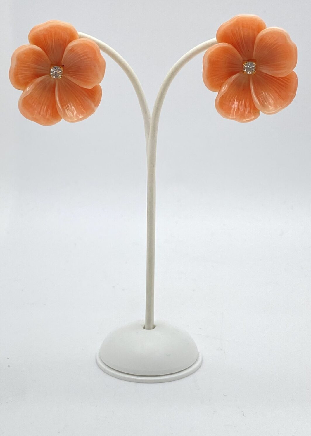 RAFFINATO PAIO DI ORECCHINI AFORMA DI FIORI DI PESCO, IN BACHELITE, CON STRASS CENTRALE DIAMOND LIKE. USA ANNI’40.