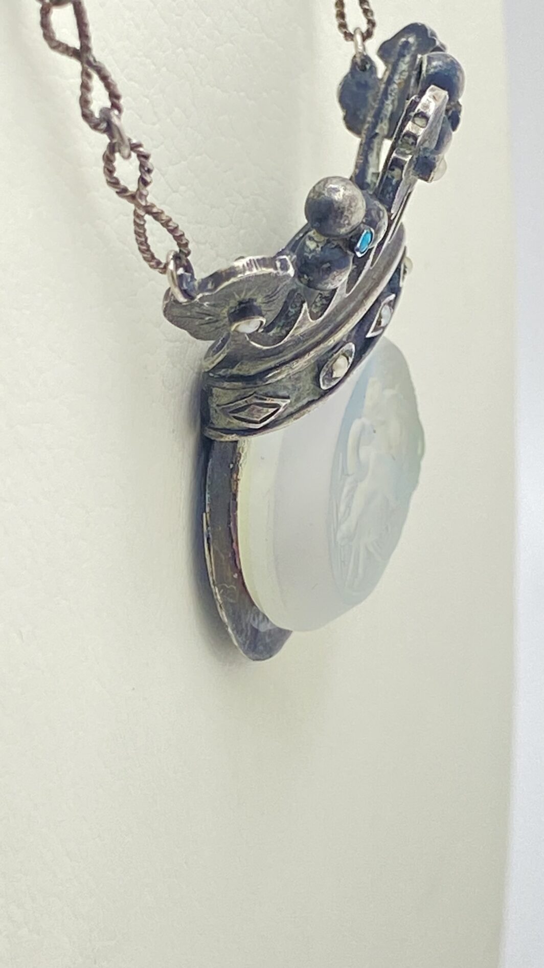 STRAORDINARIA COLLANA ART DECO, IN ARGENTO 925, CON PENDENTE A FORMA DI CORONA ORNATA DI TURCHESI E MICROPERLE, CARATTERIZZATO DA CRISTALLO SCOLPITO CON LA RAFFIGURAZIONE DEL MITO DI “GIOVE E LEDA”. INIZI XX sec. - immagine 17