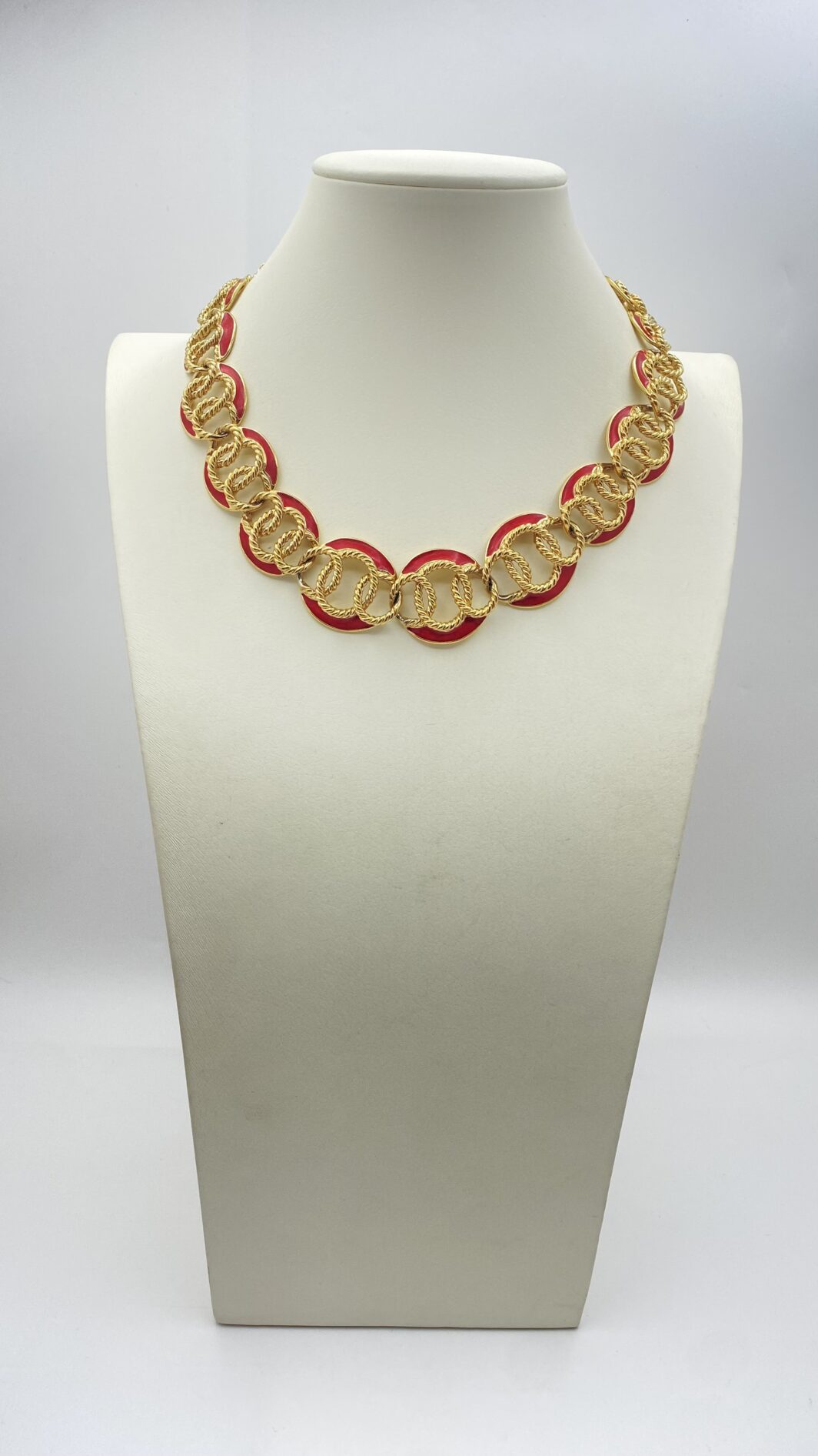 “TRIFARI”. COLLIER VINTAGE ANNI ‘80, IN METALLO GOLDTONE E SMALTO ROSSO.