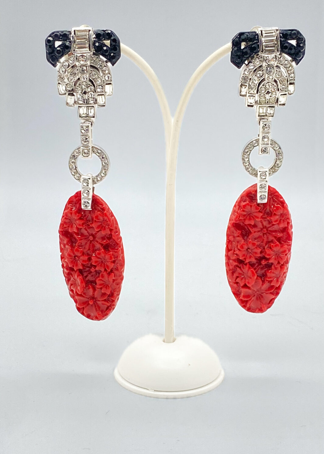 MAESTRIA DELL’ ART DECO IN UN GIOCO DI STRASS DIAMOND-LIKE, METALLO ARGENTATO E RESINE ROSSO CORALLO: L’INCANTO DI CARLO ZINI BIJOUX.