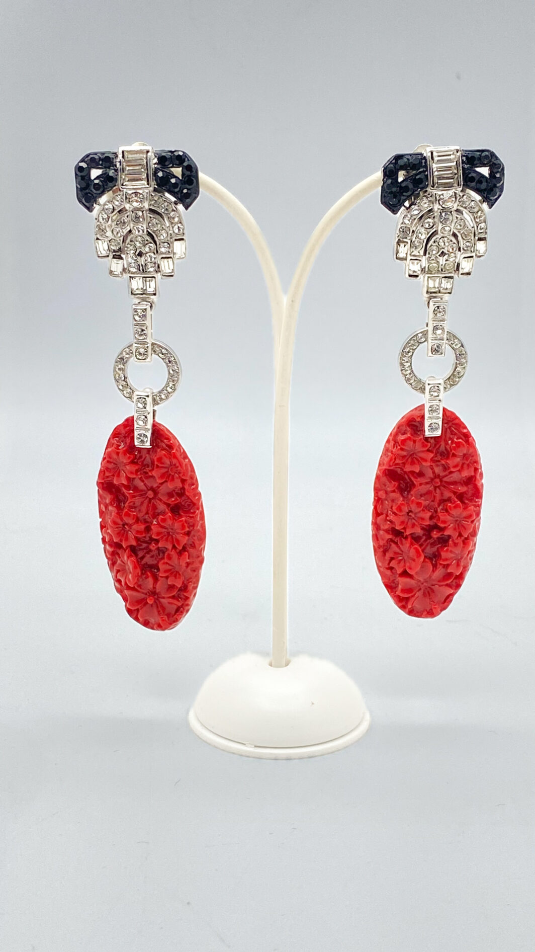 MAESTRIA DELL’ ART DECO IN UN GIOCO DI STRASS DIAMOND-LIKE, METALLO ARGENTATO E RESINE ROSSO CORALLO: L’INCANTO DI CARLO ZINI BIJOUX.