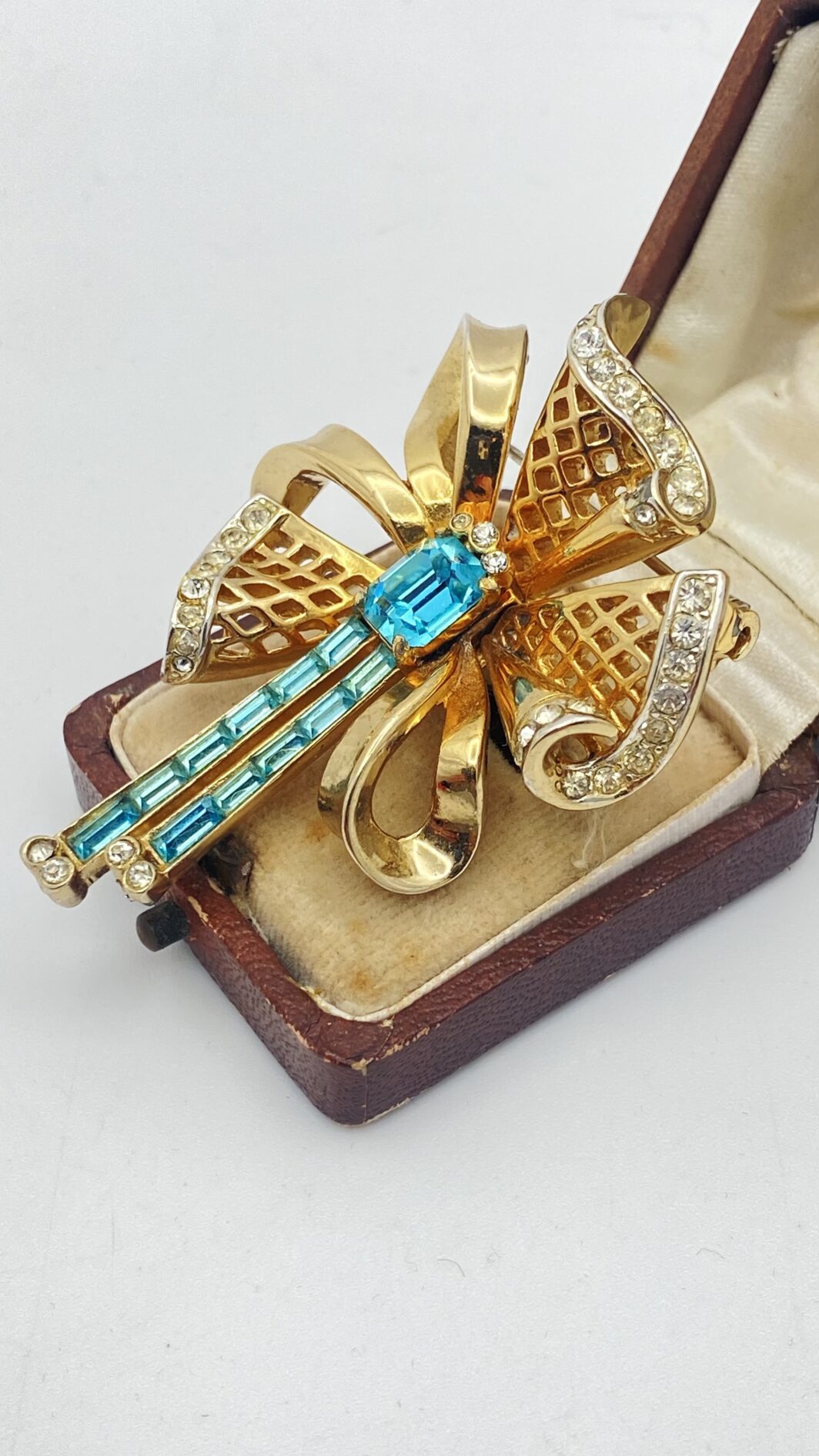 MAGNIFICA SPILLA VINTAGE ANNI’30/’40 FIRMATA CORO CRAFT – METALLO DORATO, FINEMENTE SAGOMATO A FORMA DI FIOCCO CON NAPPE, ARRICCHITO DA STRASS LUMINOSI E CRISTALLI ACQUAMARINA TAGLIO BAGUETTE. - immagine 3