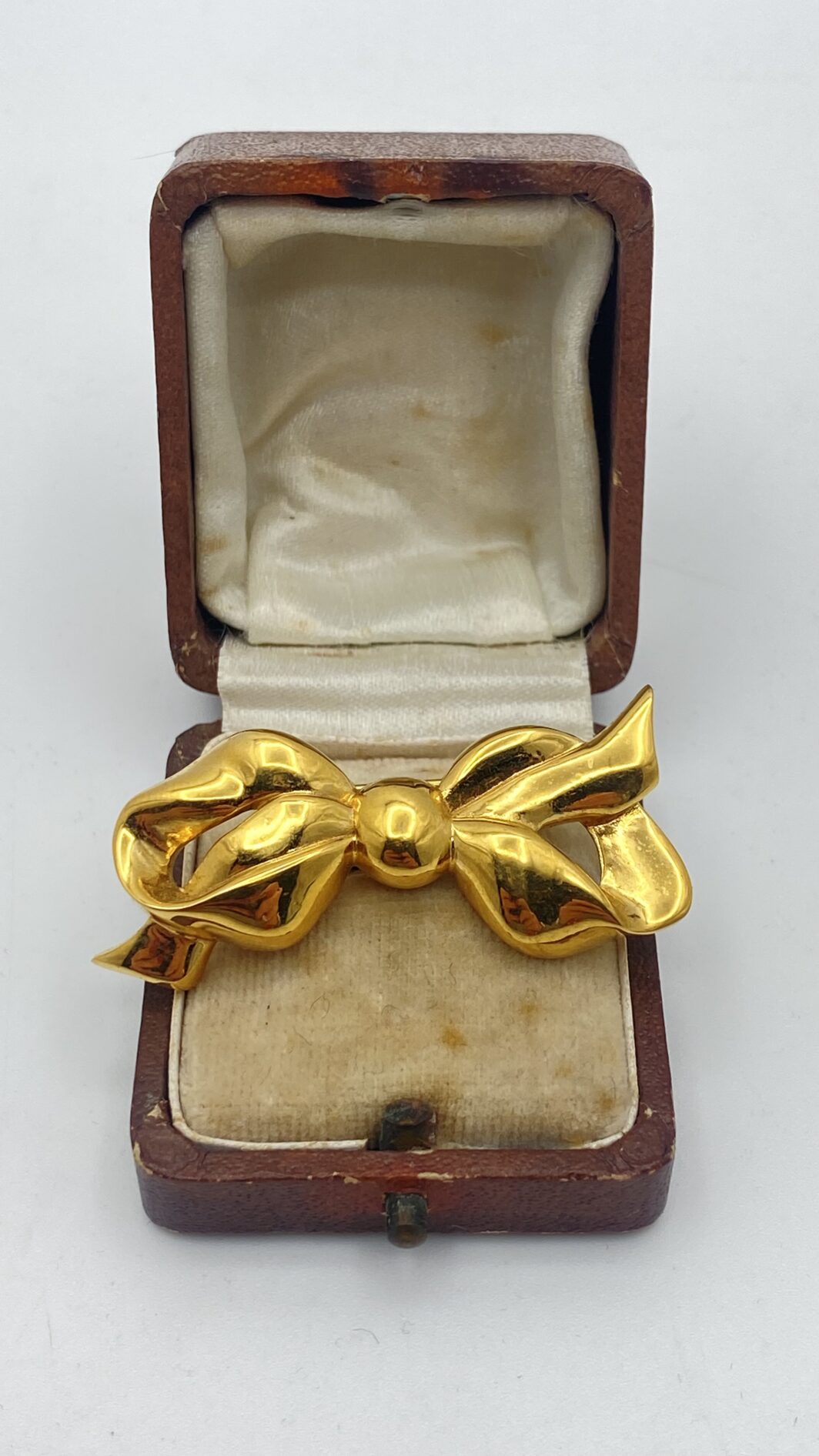 ELEGANZA SENZA TEMPO. SPILLA VINTAGE ANNI’50/‘60, A FORMA DI NODO D’AMORE FIRMATA “NINA RICCI”, IN METALLO GOLDTONE.