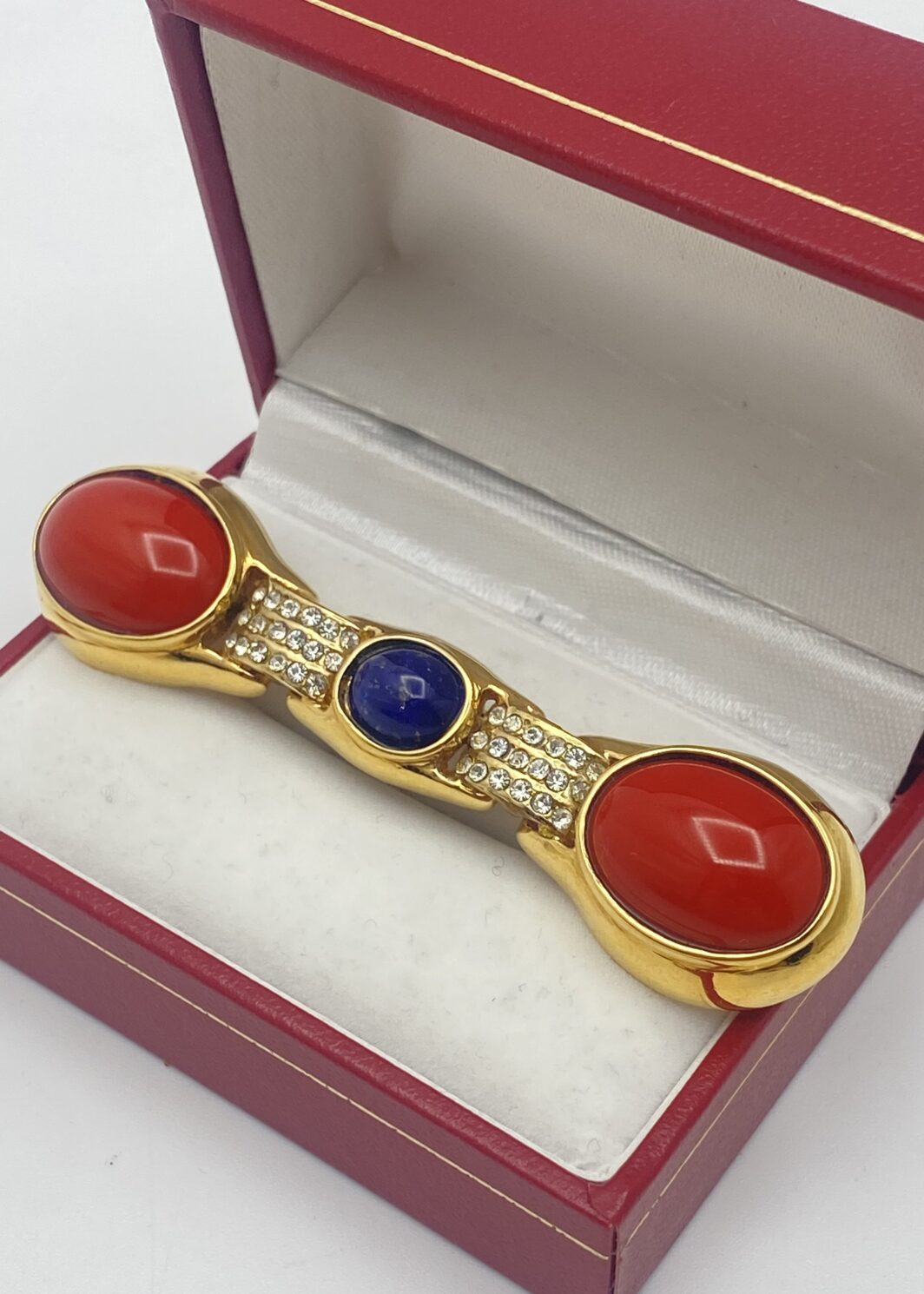 MAGNIFICA SPILLA VINTAGE DI ALTA BIGIOTTERIA FIORENTINA, FIRMATA CASCIO BIJOUX, IN METALLO GOLTONE FINEMENTE SAGOMATO, CARATTERIZZATA DA PASTE DI VETRO COLOR CORALLO E UNA RIPRODUZIONE PERFETTA DI LAPISLAZZULI ED IMPREZIOSTA DA CRISTALLI DIAMONDLIKE. ITALIA, ANNI ‘70.