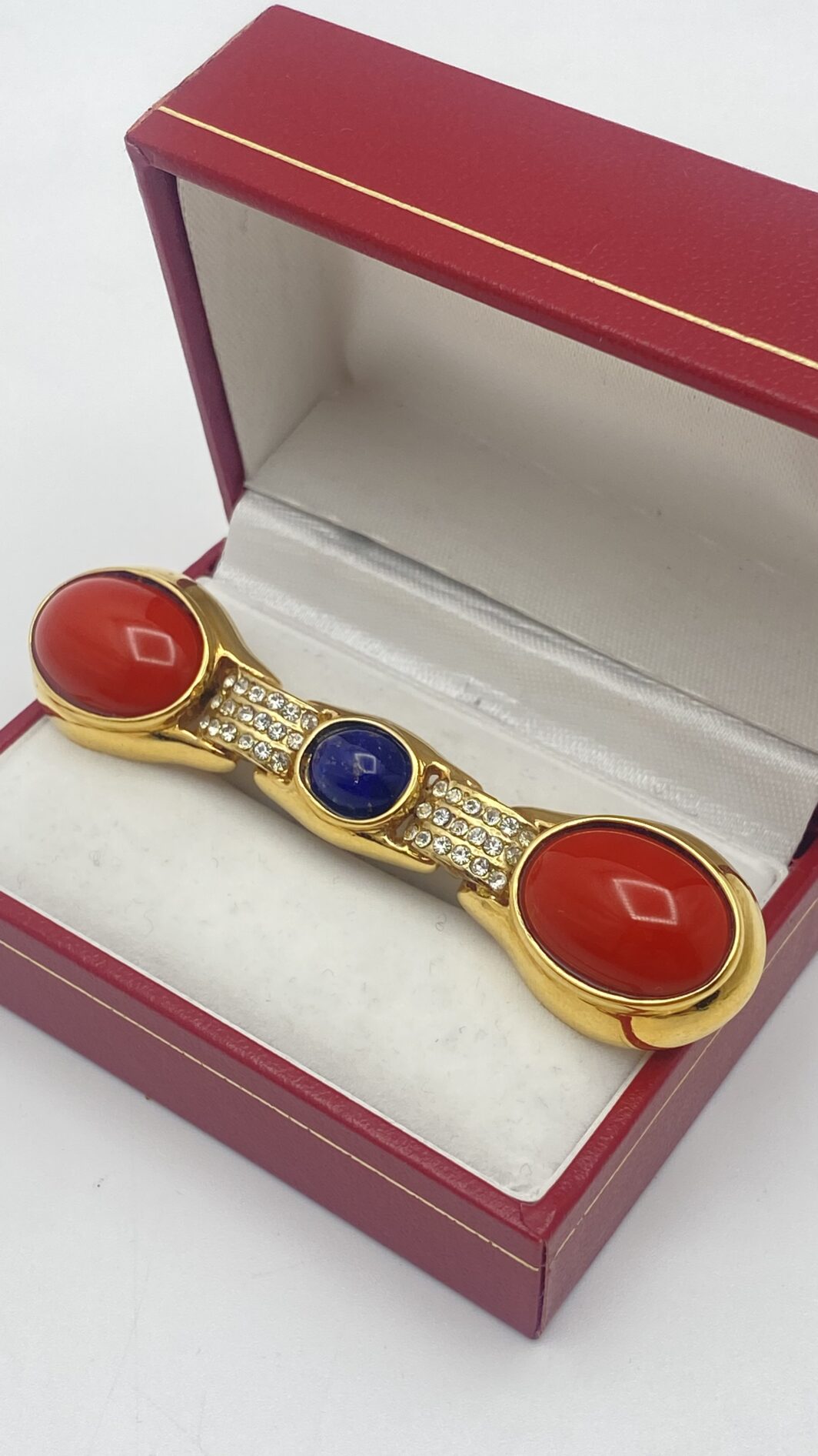 MAGNIFICA SPILLA VINTAGE DI ALTA BIGIOTTERIA FIORENTINA, FIRMATA CASCIO BIJOUX, IN METALLO GOLTONE FINEMENTE SAGOMATO, CARATTERIZZATA DA PASTE DI VETRO COLOR CORALLO E UNA RIPRODUZIONE PERFETTA DI LAPISLAZZULI ED IMPREZIOSTA DA CRISTALLI DIAMONDLIKE. ITALIA, ANNI ‘70.