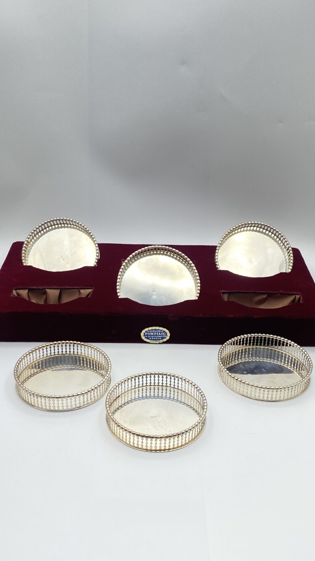 ELEGANTISSIMO SET DI SEI SOTTOBICCHIERI IN ARGENTO FINEMENTE SAGOMATO E TRAFORATO, CON CUSTODIA ORIGINALE RIVESTITA IN VELLUTO. OREFICERIA POMPILIO, GENOVA, PRIMA METÀ DEL XX sec.
