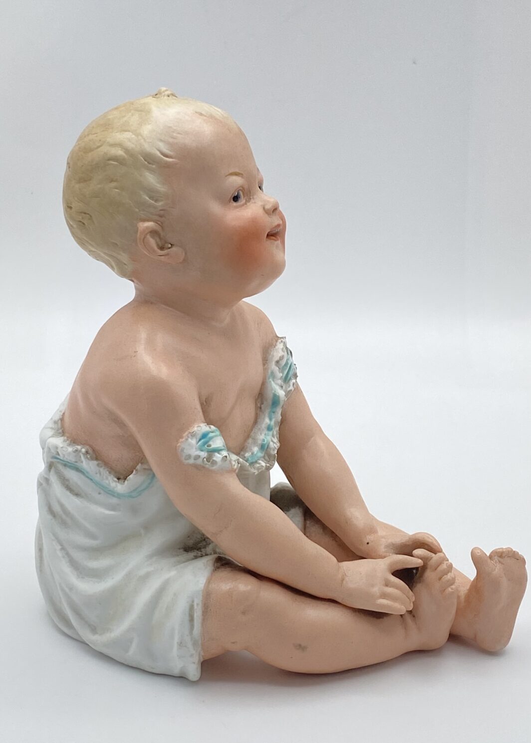 SUBLIME STATUINA “PIANO BABY” IN BISQUIT, OPERA DELLA PRESTIGIOSA CASA TEDESCA DI PORCELLANE GEBRÜDER HEUBACH. EPOCA FINE XIX, INIZI XX sec.