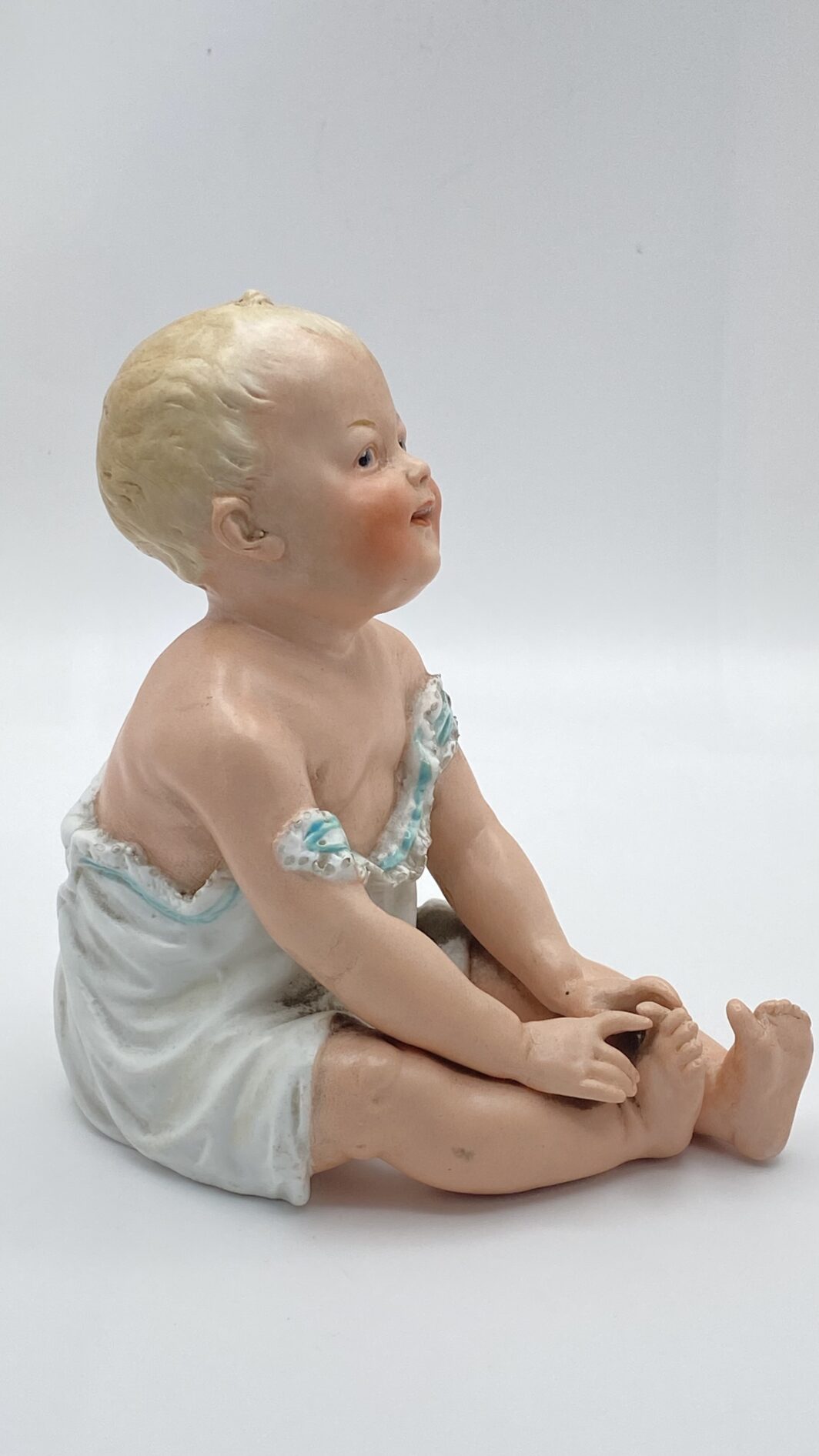 SUBLIME STATUINA “PIANO BABY” IN BISQUIT, OPERA DELLA PRESTIGIOSA CASA TEDESCA DI PORCELLANE GEBRÜDER HEUBACH. EPOCA FINE XIX, INIZI XX sec.