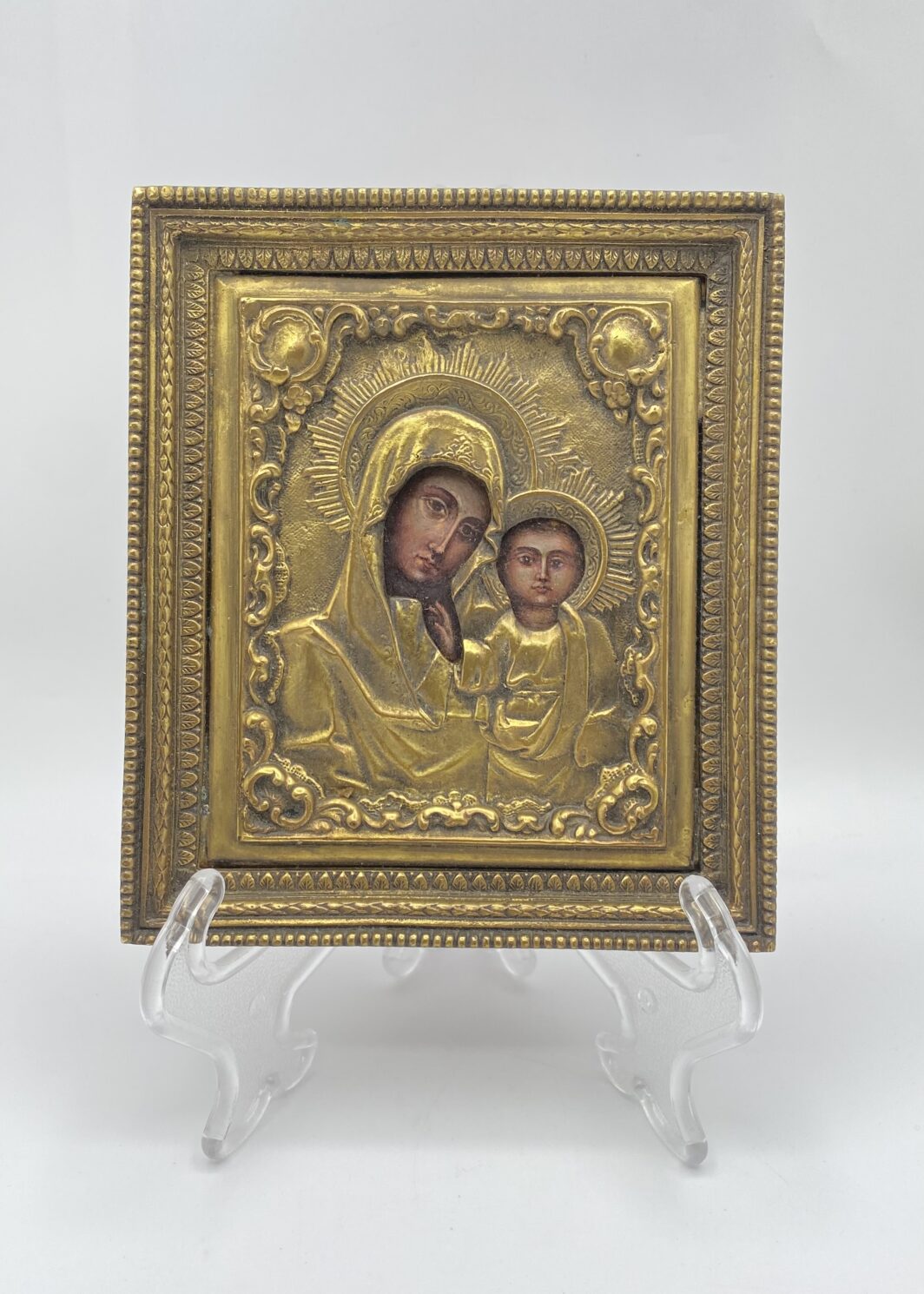 INCANTEVOLE PICCOLA ICONA DELLA MADONNA DI KAZAN, DIPINTA A MANO, CON RIZZA IN BRONZO RICCAMENTE DECORATA. RUSSIA, XX sec.