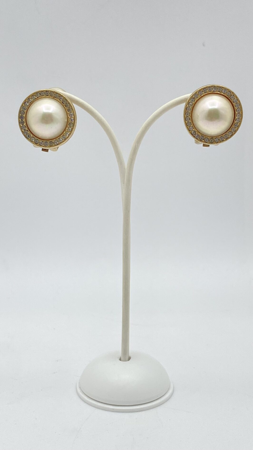 ELEGANZA SENZA TEMPO. PAIO DI ORECCHINI VINTAGE ANNI’70 FIRMATI DALLA CELEBRE MAISON DELLA MODA PARIGINA “CHRISTIAN DIOR”, IN METALLO GOLDTONE, PERLA BIJOU E CRISTALLI DIAMOND-LIKE.
