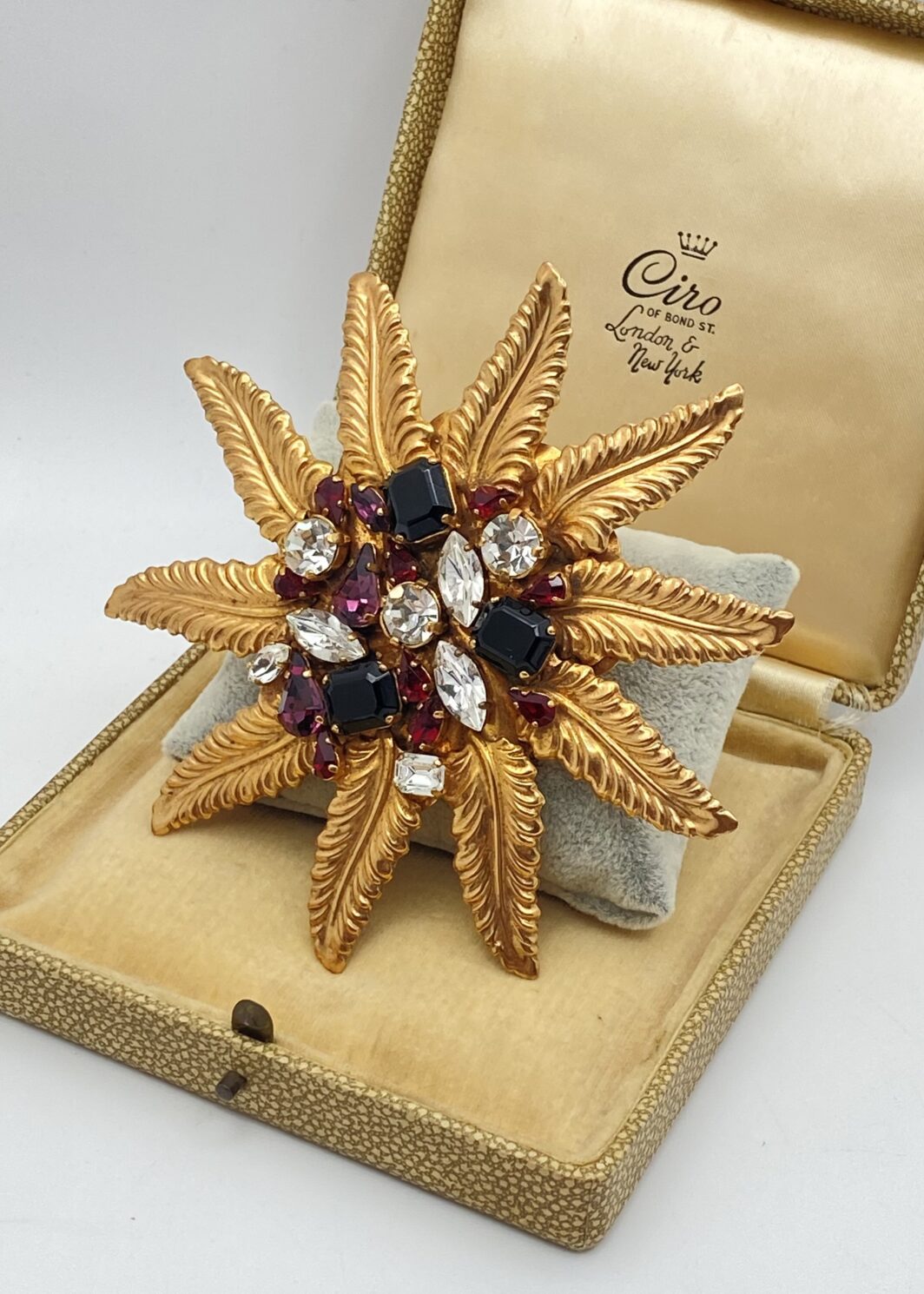 SPLENDORE DECO ANNI ’30 . SPILLA CON CRISTALLI POLICROMI E FOGLIE DORATE.