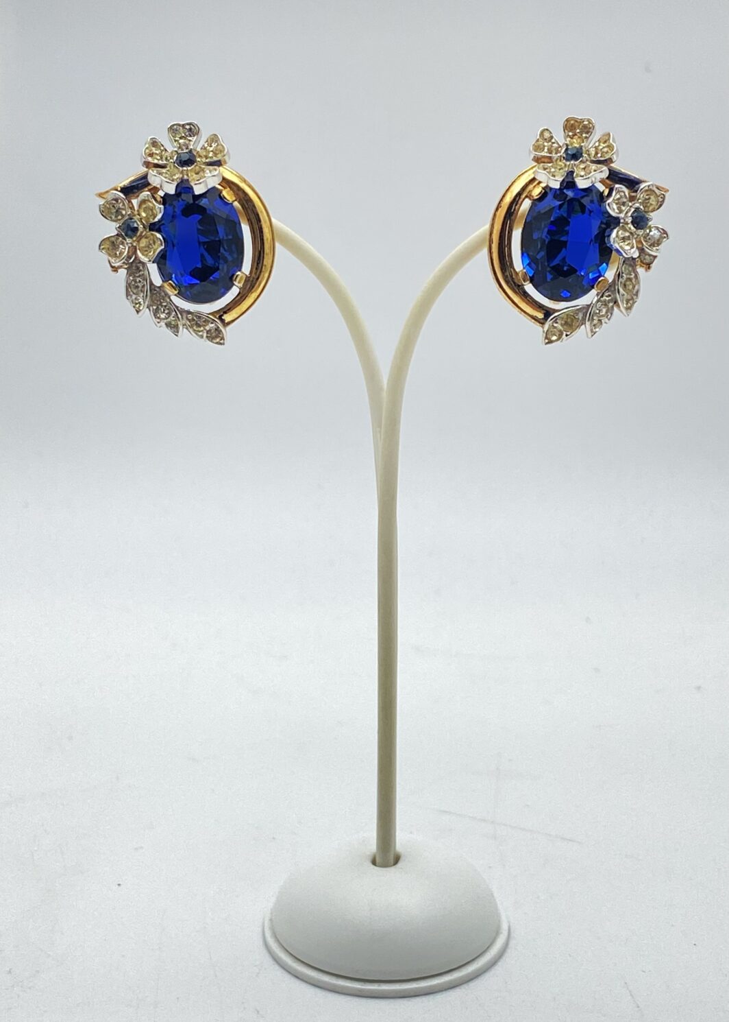 STRAORDINARI ORECCHINI FIRMATI TRIFARI, CON CORONA, ANNI ’50, IN METALLO DORATO – DESIGN ALFRED PHILIPPE CON CRISTALLI ZAFFIRO, RARITÀ DA COLLEZIONE.