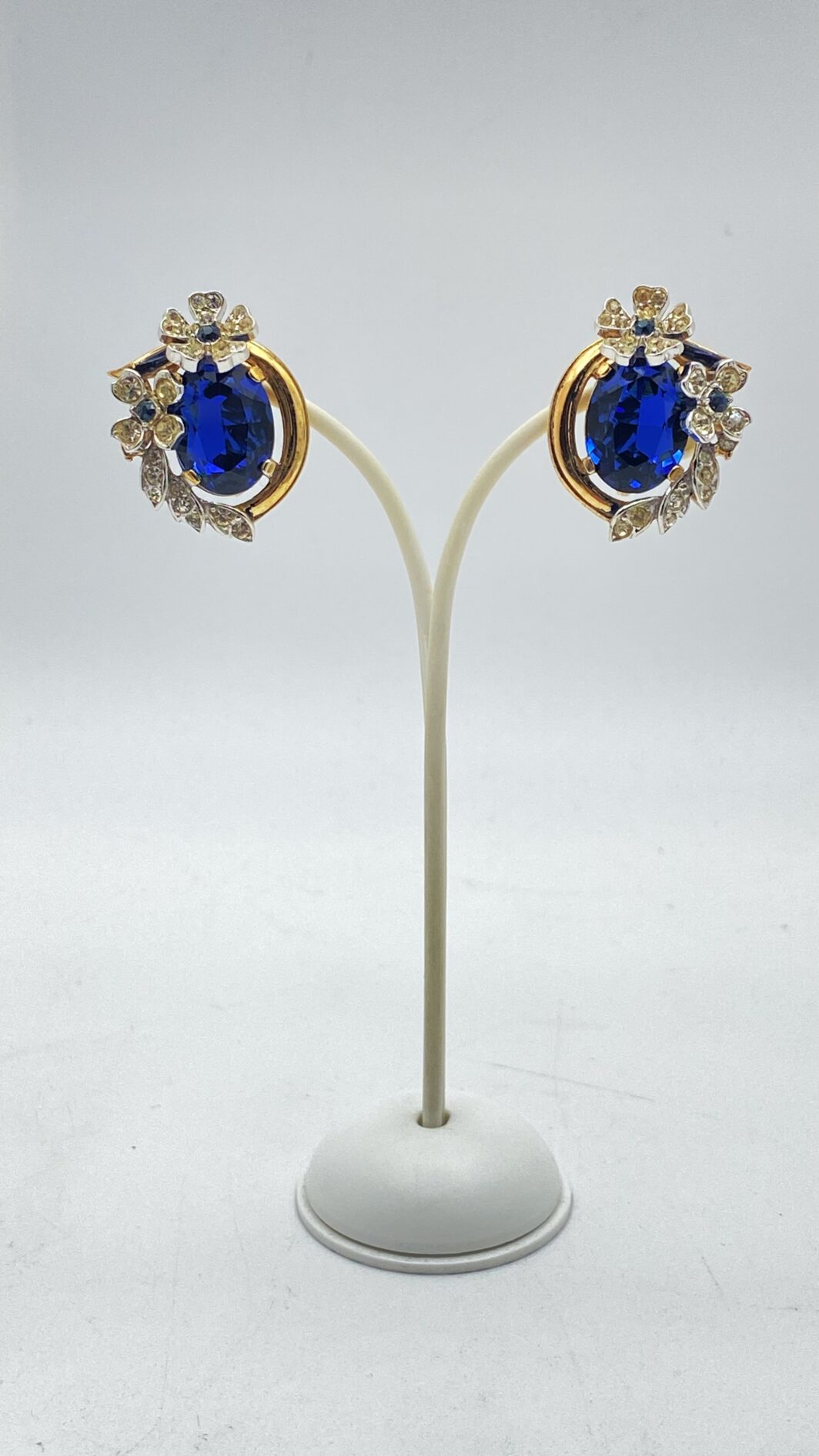 STRAORDINARI ORECCHINI FIRMATI TRIFARI, CON CORONA, ANNI ’50, IN METALLO DORATO – DESIGN ALFRED PHILIPPE CON CRISTALLI ZAFFIRO, RARITÀ DA COLLEZIONE.