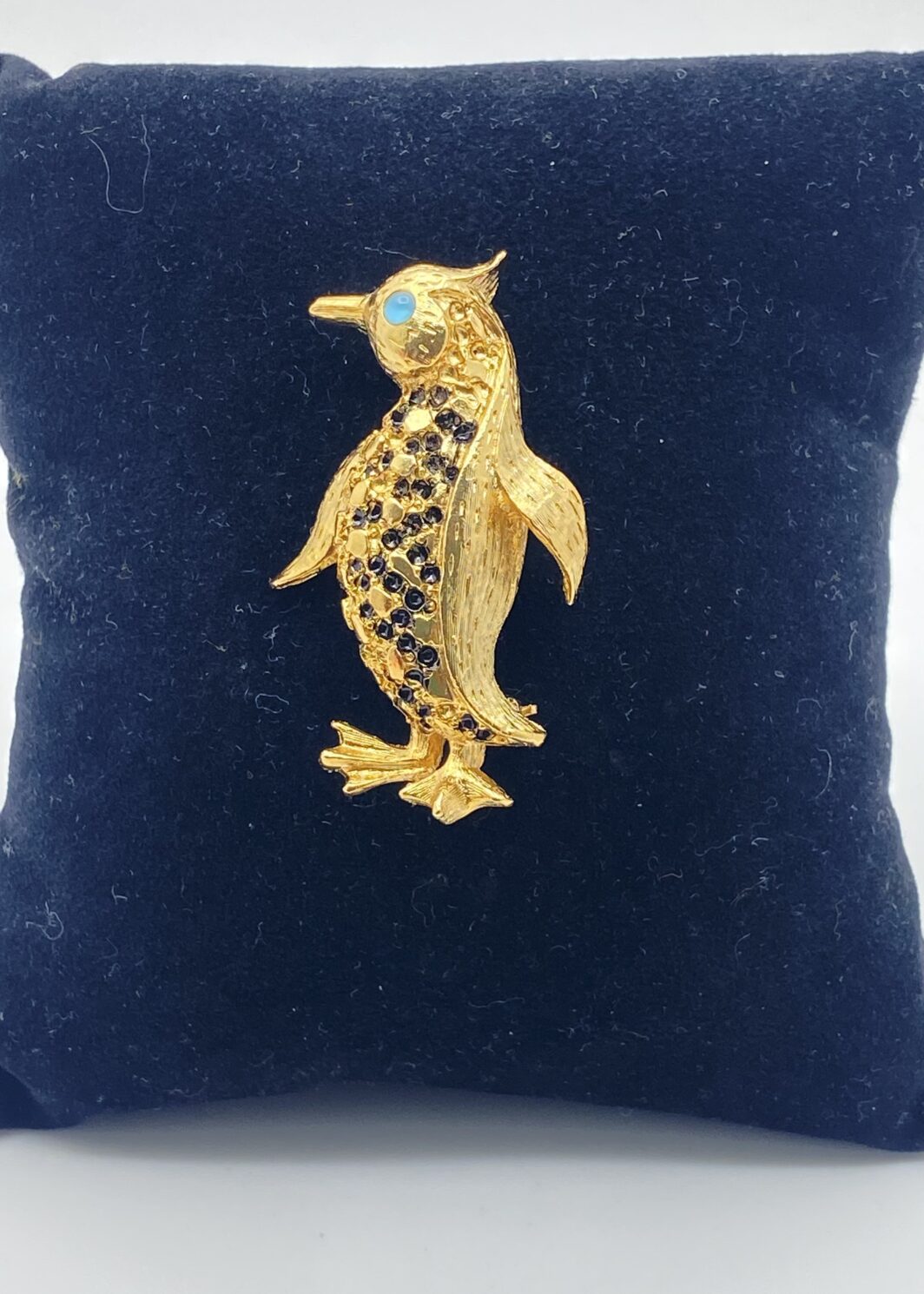 SPLENDIDA SPILLA VINTAGE ANIMALIER, A FORMA DI PINGUINO IN METALLO DORATO CON CRISTALLI NERI E OCCHIO TURCHESE FIRMATA OLEG CASSINI.