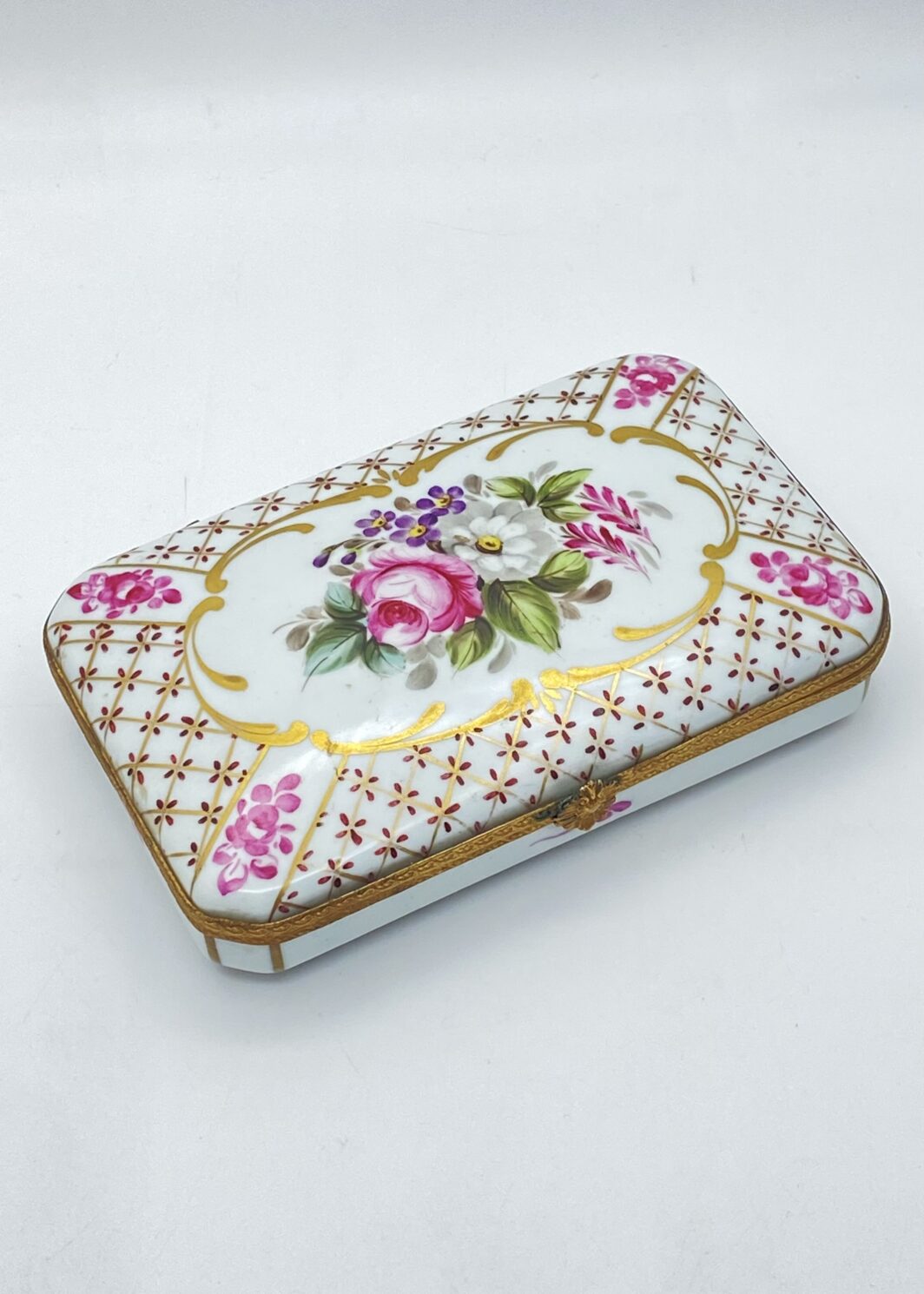 RAFFINATA SCATOLA PORTAGIOIE IN PORCELLANA MEISSEN CON PROFILI IN BRONZO DORATO E DECORO FLOREALE POLICROMO. GRMANIA, ANNI ’40