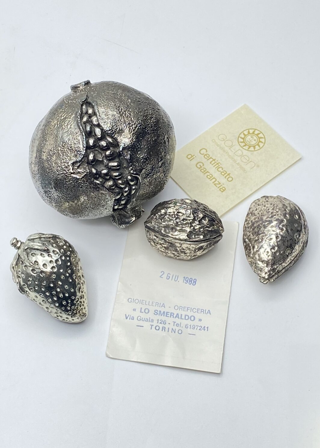 RARA COLLEZIONE D'EPOCA DI FRUTTI E SECCAGLI IN ARGENTO LAMINATO A SPESSORE – FRUTTA RIVESTITA DI MANIFATTURA ARTIGIANALE “GOLDEN”, COMPLETA DI GARANZIA E CONFEZIONE ORIGINALE "LO SMERALDO" TORINO, 1988