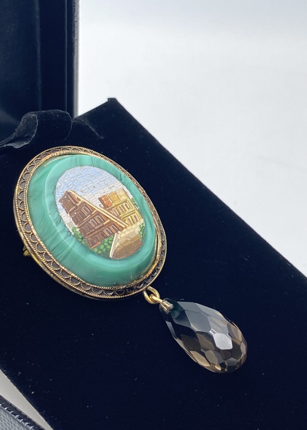 RARITÀ DA COLLEZIONE: ORIGINALE SPILLA GRAND TOUR CON CORNICE IN ORO 18 CARATI FINEMENTE SAGOMATA, CON MICROMOSAICO ROMANO SU MALACHITE E PENDENTE IN TOPAZIO FUMÈ, TAGLIO BRIOLETTE. ITALIA, SCUOLA ROMANA, 1830 CIRCA